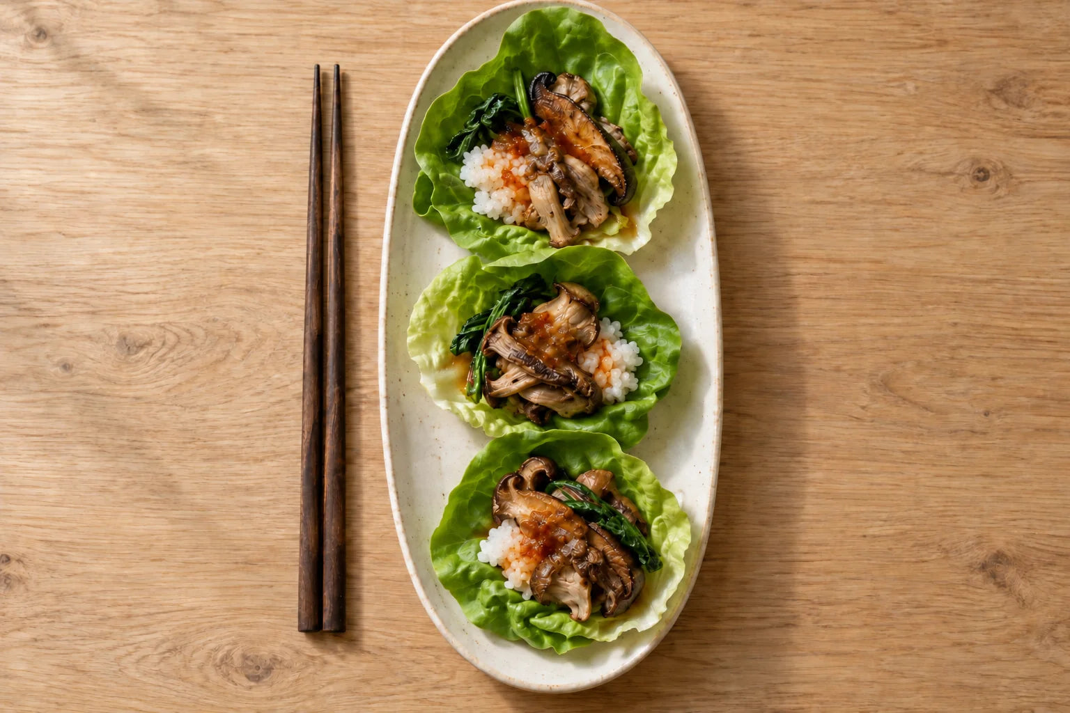 Lettuce wraps filled with rice, browned mushrooms and greens, finished with JANG hot sauce.